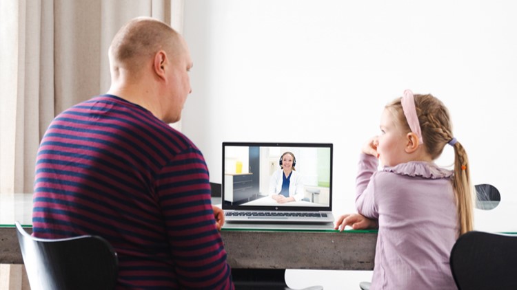 Aikuinen ja lapsi keskustelevat hoitajan kanssa tietokoneen välityksellä.